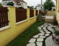 Pohled na již zatravněný "zelený pás" lemující kamenný chodníček